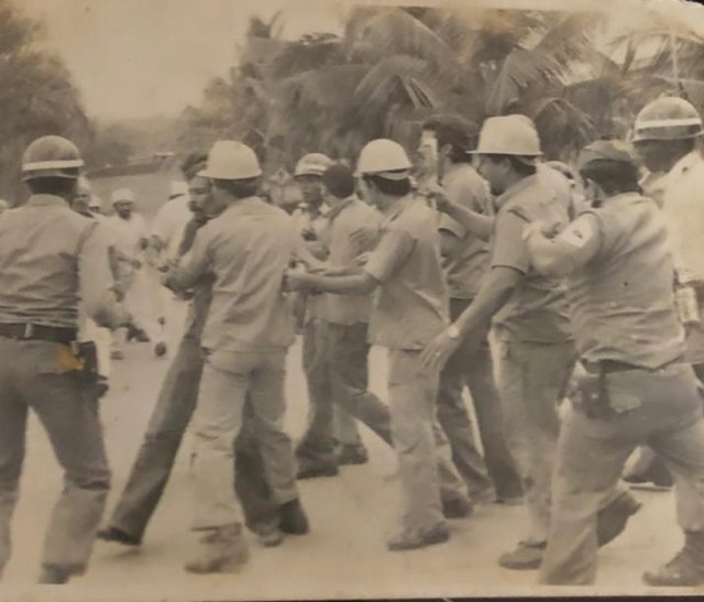 Trabajadores protegen a Miguel Medina, secretario general del gremio, ante la represión policial; Capellán, Báez, D Co, Germán y Lencho Paulino (EPD), fue brutalmente golpeado por un sargento mayor.